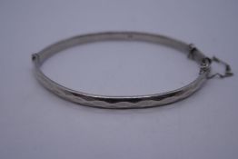 Georg Jensen; A silver bangle by Georg Jensen, marked G J LTD, Hallmarked, 7cm diameter with safety