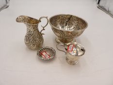 A quantity of four silver items to include a silver repousséd bowl on a circular foot with central v