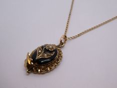 9ct yellow gold neckchain hung with antique yellow metal oval pendant with black enamel and applied