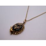 9ct yellow gold neckchain hung with antique yellow metal oval pendant with black enamel and applied