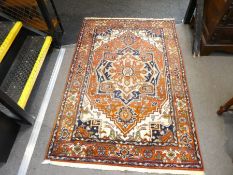 A modern rug having central spandrel with stylised border, 183cm x 122cm