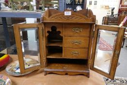 An early 20th century oak tobacco cabinet having three drawers