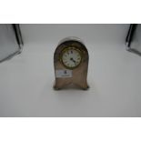 A nice looking silver desk clock standing on four ball feet. 13cm x 8cm approx. Nice shape with arch