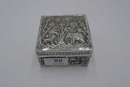 A chased, white metal cigarette box decorated with animals and palm trees 5.39ozt approx