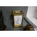 An old brass, carriage clock with striking movement and enamel dial