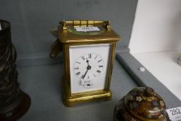 An old brass, carriage clock with striking movement and enamel dial