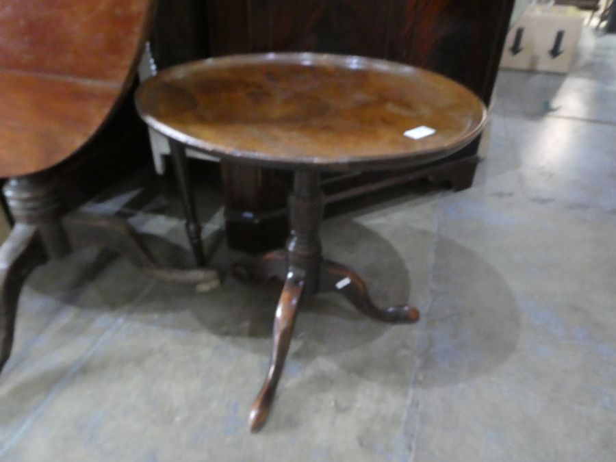 An antique tripod table having mahogany dish top