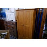 A modern pine wardrobe with one long drawer