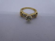 Modern 18K yellow gold solitaire diamond ring approx 0.25 carat, the shoulders inset with 4 baguette