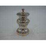 An ornate Victorian silver pepper mill with decorative chased design and central vacant cartouche. H