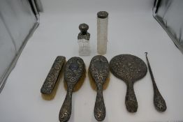 Silver dressing table items to include brushes, hand mirror, button hook, and cut glass silver toppe