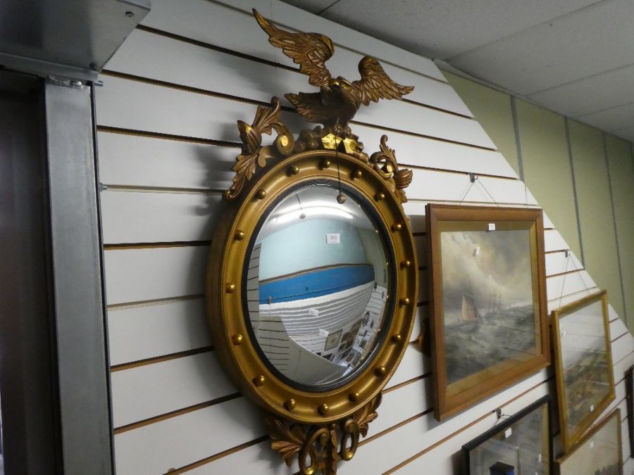 An old gilt convex wall mirror having Eagle Surmount