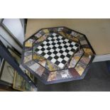 An antique octagonal specimen marble top with central chess board on a made up base; 65cms