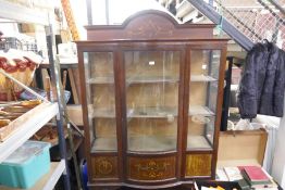 An Edwardian inlaid mahogany display cabinet having central bow fronted door