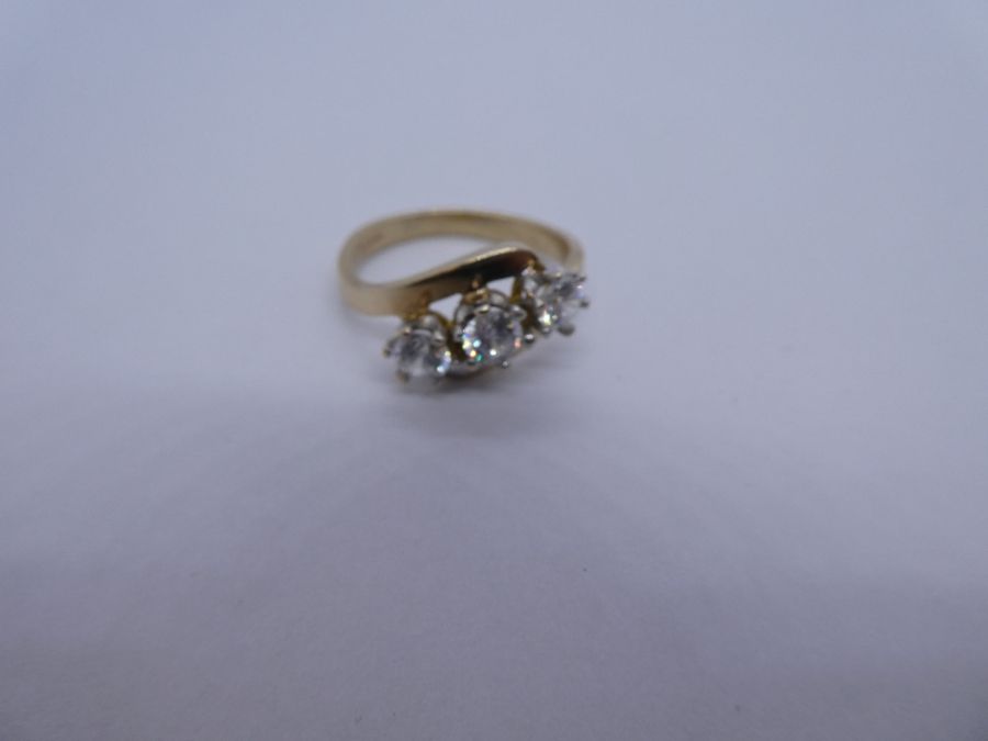 9ct yellow gold dress ring of crossover design inset three clear stones, Size N/O, 3.8g approx