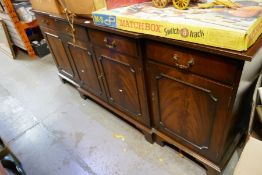 A reproduction mahogany breakfront sideboard