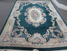 A large Chinese carpet having a green field with central floral spandrel, 368cm x 278cm