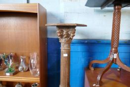An antique carved pedestal decorated lion and cherubs with fluted column and a mahogany tilt top tab