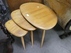 Ercol, a nest of three pebble shaped tables, 66cm