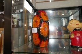 A vase decorated orange flowers by Anita Harris, Staffordshire