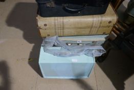 A vintage Singer sewing machine, a quantity of suitcases and sundry textiles