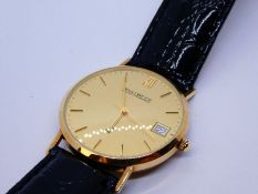 A 9ct Jean Pierre gold watch with a black leather strap. Circular head with baton hour marks and a s