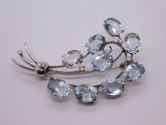 Contemporary 18ct white gold diamond and aquamarine floral spray design brooch, comprising 9 oval fa