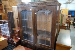 A leaded glass bookcase, a small desk, a Pembroke table and 2 chairs