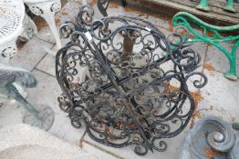 A heavy metal parasol base and three scroll work panels