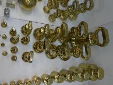 A quantity of antique brass bell weights, some marked Boa of Croydon, the largest 14lbs