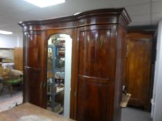 An Edwardian inlaid mahogany triple wardrobe having central mirrored door 197cm