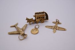 Four 9ct yellow gold charms to include two aeroplanes, small St Christopher and a horse drawn double