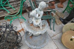 A two tier bird bath decorated cherub and shells