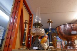 A cast iron and glass oil lamp and a pair of candlesticks
