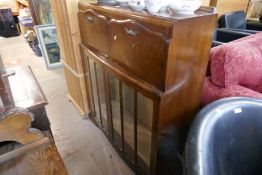 A vintage Walnut display cabinet, having glazed doors with flaps above