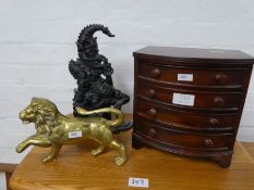 A miniature mahogany bow fronted chest, a brass Lion and a Punch doorstop