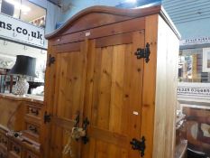 A Mexican pine 2 door wardrobe with drawers below and a 2 drawer bedside chest