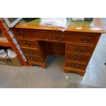 A leather-topped kneehole desk of small proportions, with Maple veneer