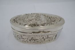 A silver Art Nouveau box, heavily decorated in foliate design having figure on lid. Oval design, dec