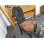 An old Burmese carved side chair, the back decorated animals and foliage