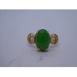 9ct yellow gold Oriental design ring with central cabochon cut jade, flanked with panels depicting c