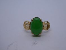 9ct yellow gold Oriental design ring with central cabochon cut jade, flanked with panels depicting c