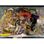 A large tray containing modern costume jewellery, including necklaces, bracelets, watches, simulated