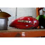 Two vintage motorbike petrol tanks, one 'Kawasaki', the other being branded 'Suzuki'