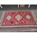 A geometric rug having red field with 3 central diamond medallions 206cm x 127cm