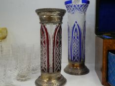 Two similar cylindrical coloured and cut glass vases having white metal decoration, the largest 30cm