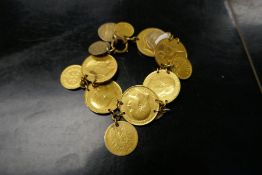Gilt charm bracelet comprising old coins, including 1907, 1906, 1904, 1910, half pennies, 1897 one c