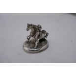 A miniature silver horse and figure with wings on oval base, possibly French, however mark worn. 5cm