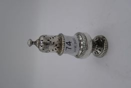 A Georgian silver pepper with gadrooned border, pierced, circular foot, with gadrooned body and lid.