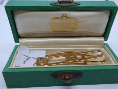 Cartier; a 14K yellow gold tie clip inscribed with initials and set blue stone, marked 14K Cartier,